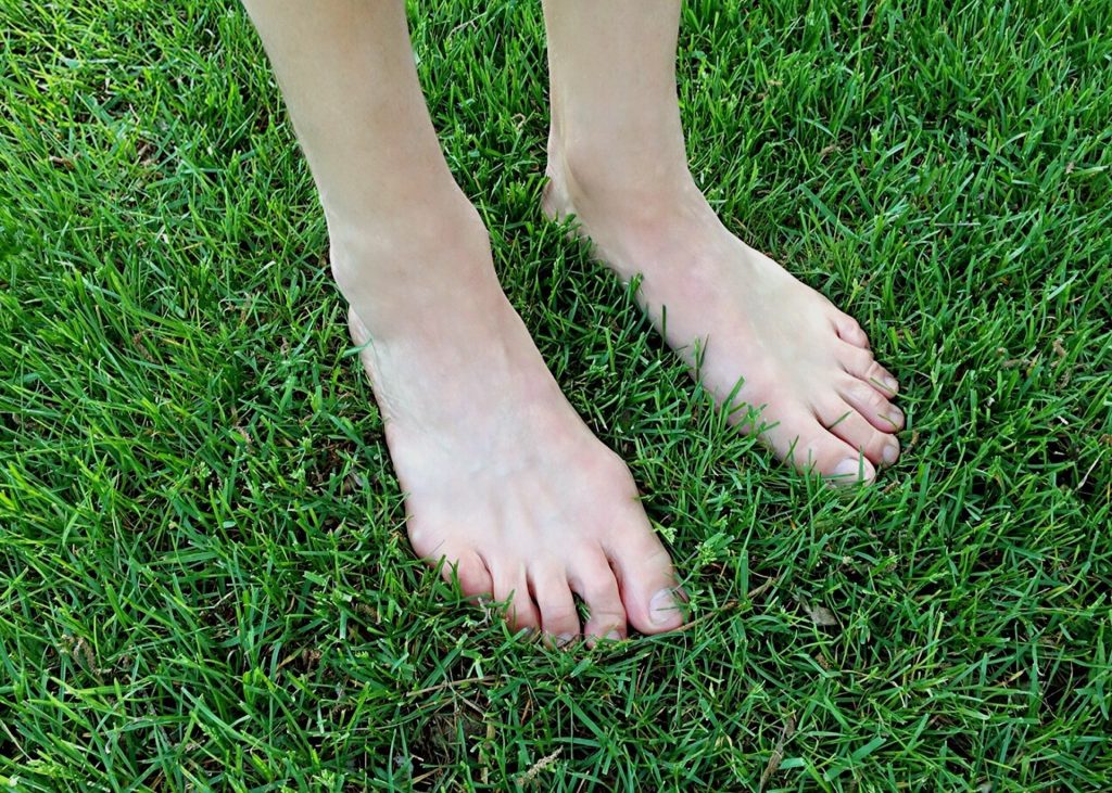 met je blote voeten in het gras