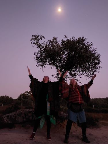 srivalli en yvonne onder een olijfboom bij een opkomende volle maan bij anta grande do zambujeiro